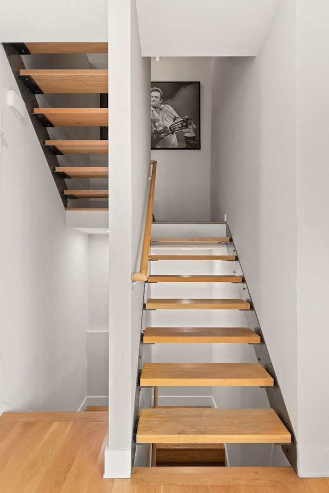 stairway with baseboards and wood finished floors