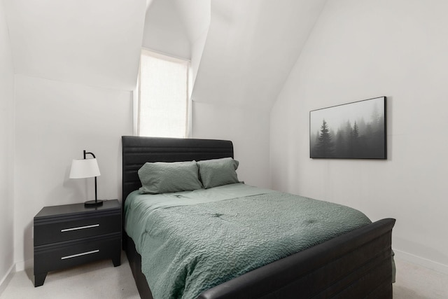 bedroom featuring baseboards, vaulted ceiling, and light colored carpet