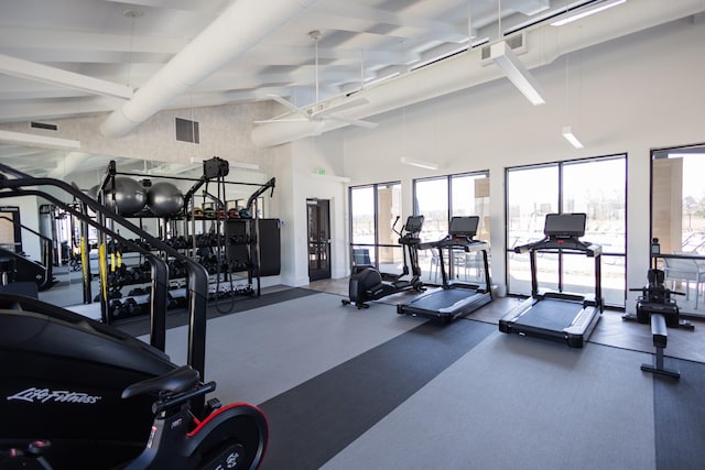 gym featuring visible vents and a towering ceiling