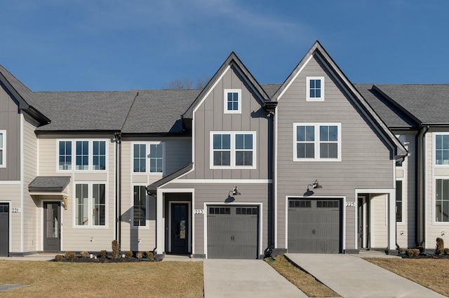 multi unit property featuring a garage, concrete driveway, a shingled roof, and board and batten siding