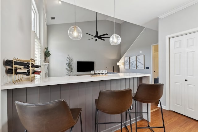 bar featuring visible vents, ceiling fan, wood finished floors, vaulted ceiling, and pendant lighting