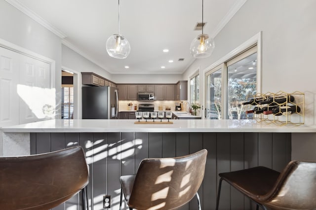 kitchen with stainless steel appliances, a breakfast bar, a sink, and a wealth of natural light