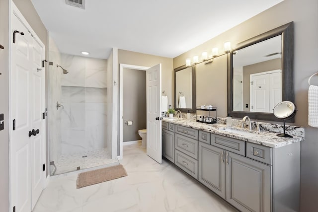 bathroom with toilet, a sink, marble finish floor, a marble finish shower, and double vanity