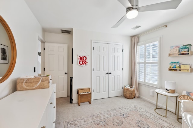 living area with light carpet, ceiling fan, visible vents, and baseboards