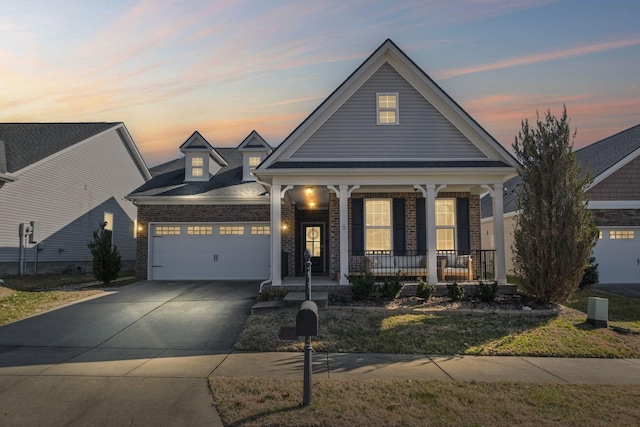 view of front of property featuring a garage, concrete driveway, a porch, and brick siding