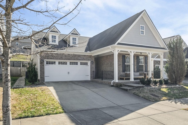 view of front of house featuring an attached garage, covered porch, brick siding, fence, and driveway