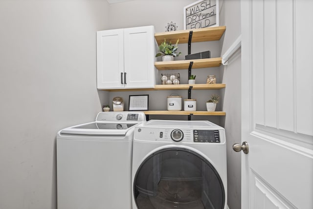 clothes washing area featuring cabinet space and washing machine and clothes dryer