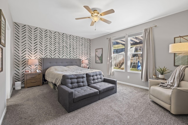 bedroom featuring carpet floors, an accent wall, baseboards, and a ceiling fan