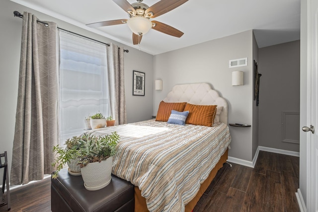 bedroom featuring a ceiling fan, baseboards, visible vents, and wood finished floors