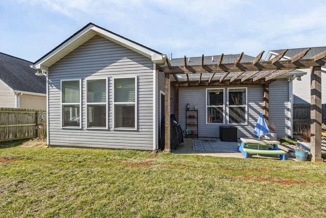 rear view of property with a pergola, a patio area, fence, and a lawn