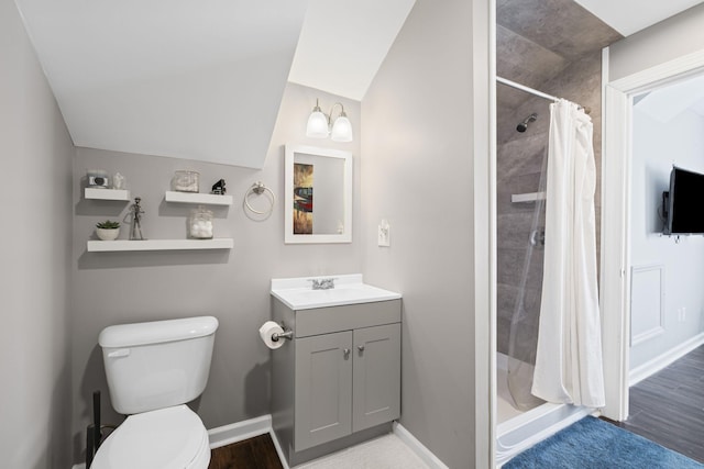 bathroom featuring a stall shower, baseboards, vanity, and toilet