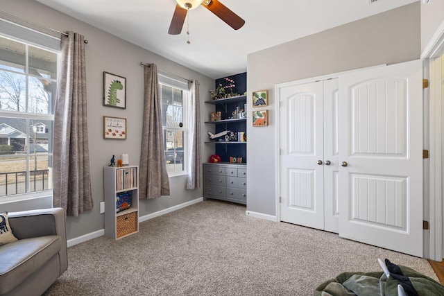 living area with carpet floors, a wealth of natural light, and baseboards