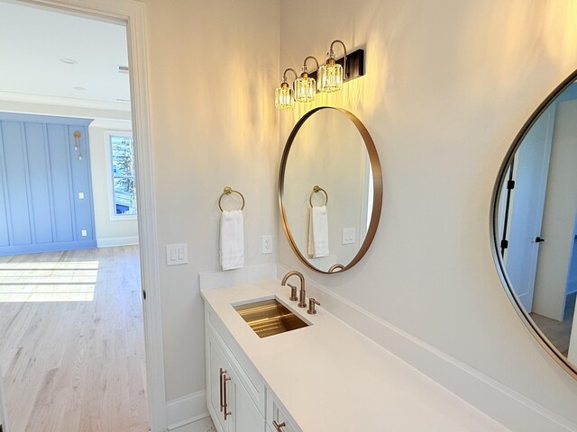 bathroom featuring vanity, baseboards, and wood finished floors