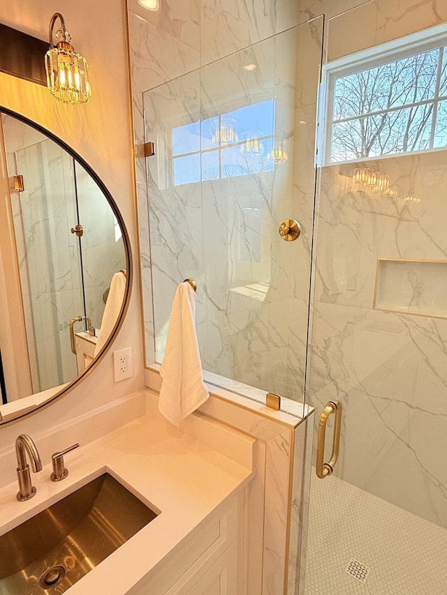 bathroom with plenty of natural light, a marble finish shower, and vanity