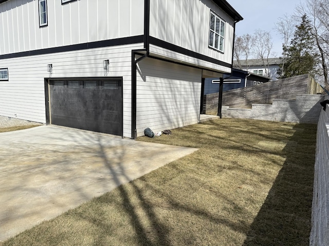 view of property exterior with board and batten siding, driveway, and an attached garage