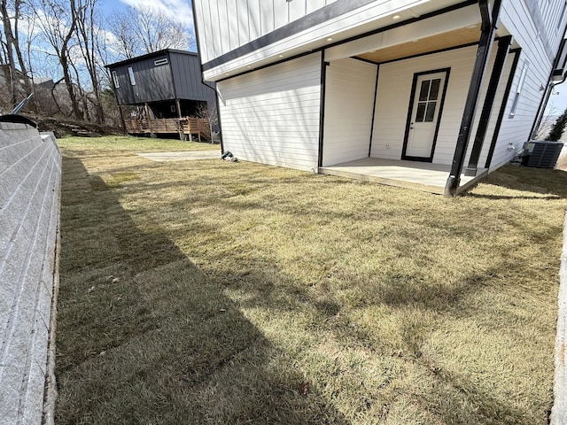 view of yard with fence, a patio, and central AC unit