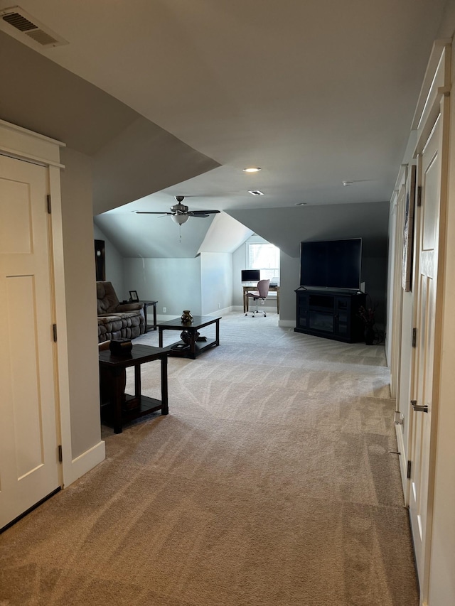 corridor featuring lofted ceiling, baseboards, visible vents, and light colored carpet