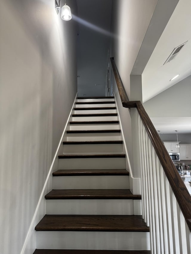 staircase with visible vents and baseboards