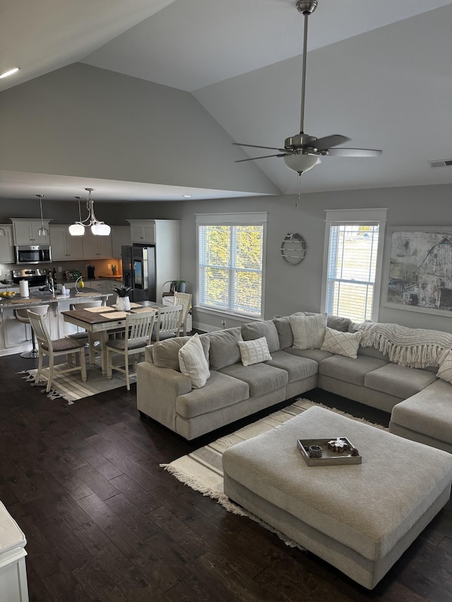 living room featuring a ceiling fan, visible vents, dark wood finished floors, and high vaulted ceiling