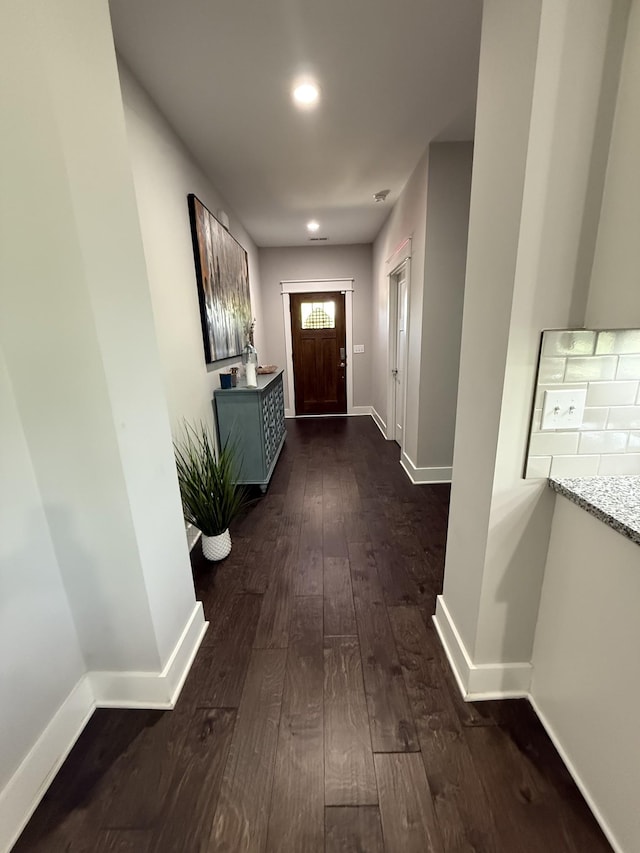 corridor featuring dark wood-style floors and baseboards