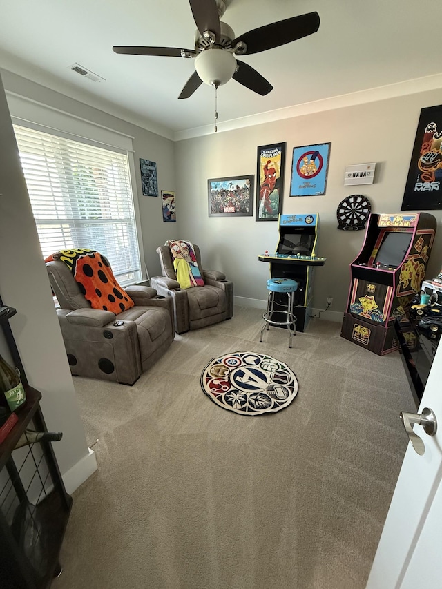 living room with crown molding, a ceiling fan, visible vents, baseboards, and carpet floors