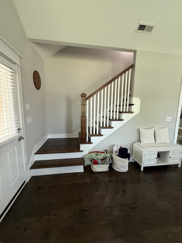 stairs with wood finished floors and visible vents