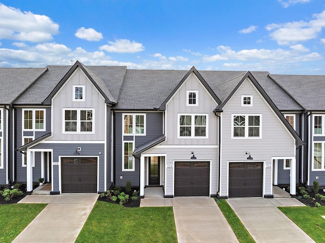 view of front of house with driveway, a shingled roof, board and batten siding, and a front lawn