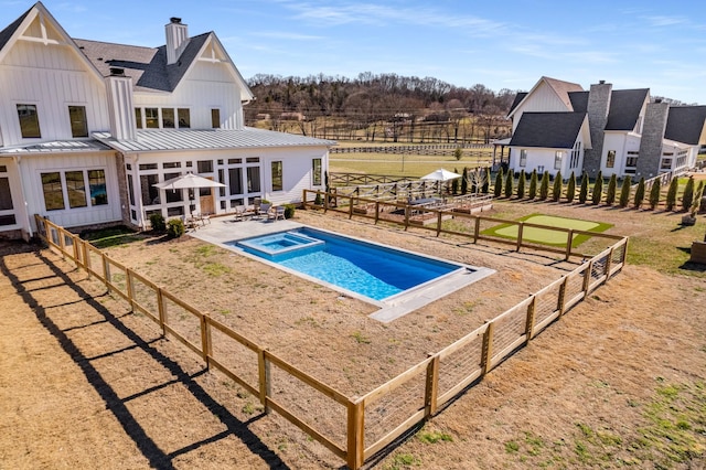 view of swimming pool featuring fence private yard, a pool with connected hot tub, and a patio