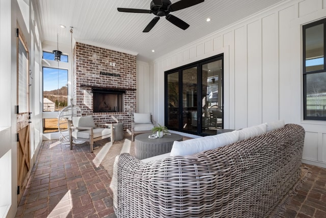 view of patio / terrace featuring an outdoor living space with a fireplace and a ceiling fan