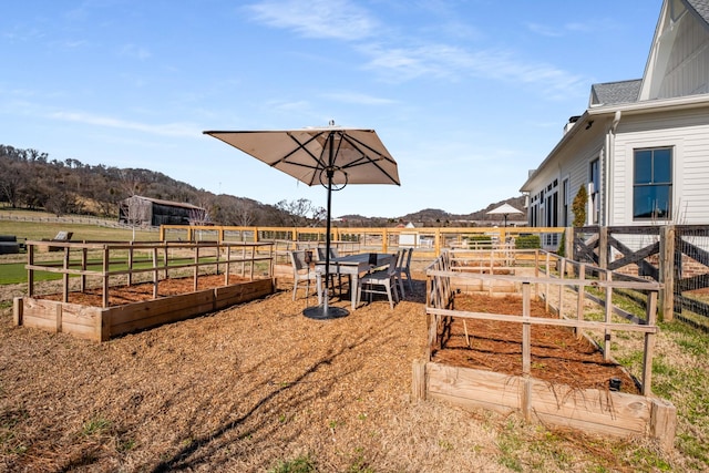 view of yard featuring a mountain view, a rural view, a vegetable garden, and fence