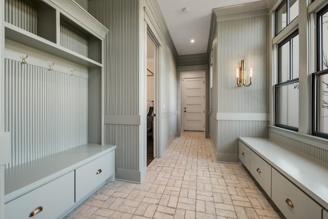 mudroom featuring brick floor, recessed lighting, crown molding, and wallpapered walls