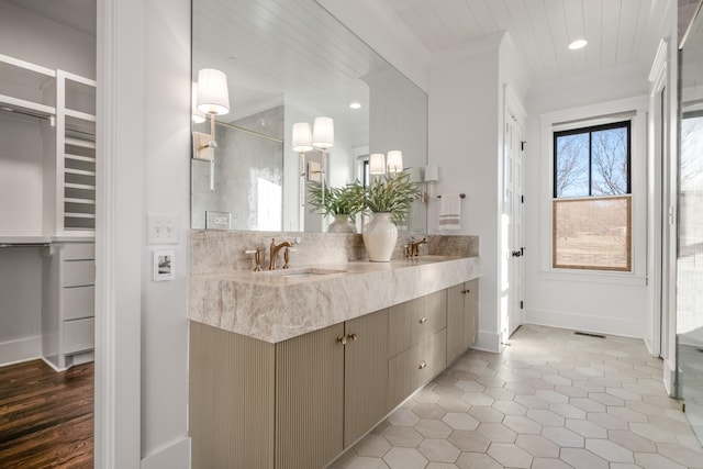 full bathroom featuring double vanity, baseboards, a sink, and recessed lighting