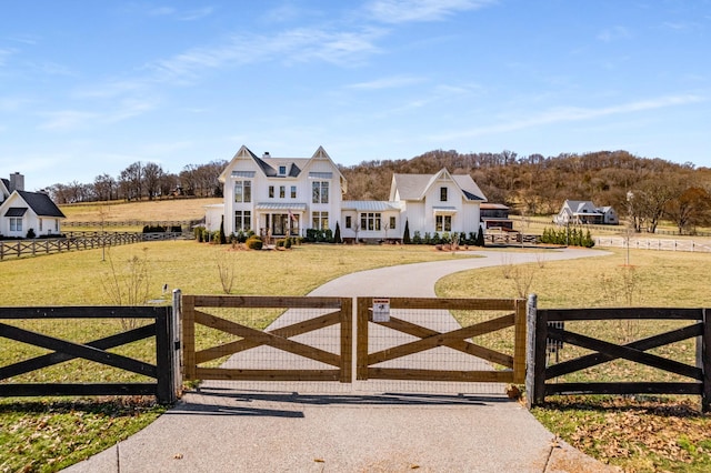 view of gate featuring a fenced front yard and a lawn