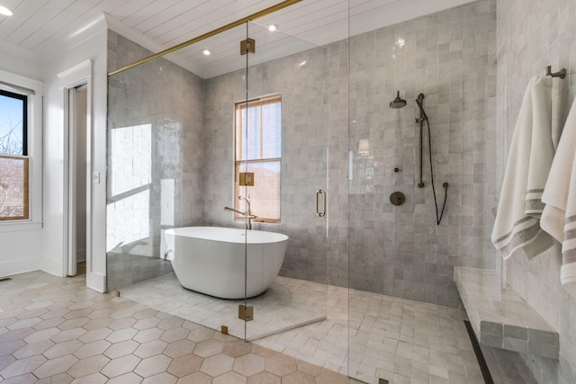 bathroom with a freestanding bath, a stall shower, a wealth of natural light, and tile walls