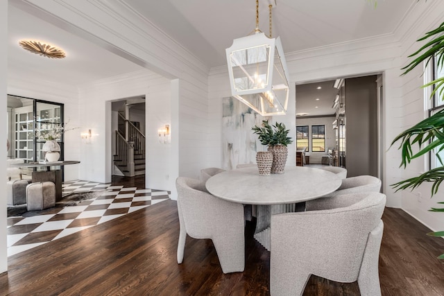 dining room with ornamental molding, a notable chandelier, stairway, and wood finished floors