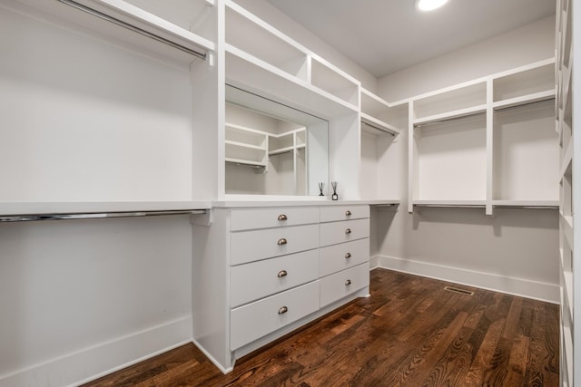 walk in closet with dark wood-style flooring