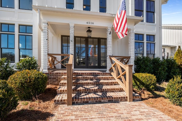 property entrance featuring board and batten siding, french doors, and a porch