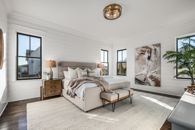 bedroom with baseboards, wood finished floors, and crown molding