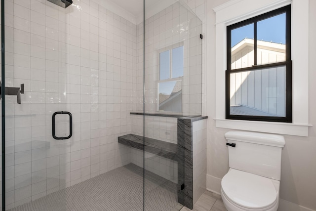 bathroom with baseboards, a shower stall, and toilet