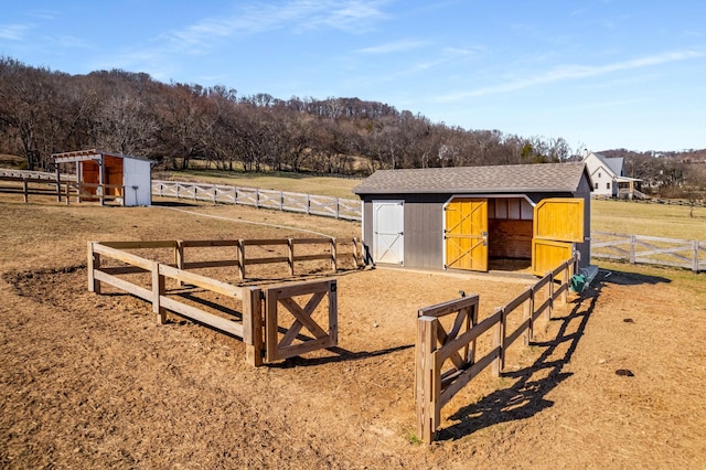 view of horse barn featuring a rural view