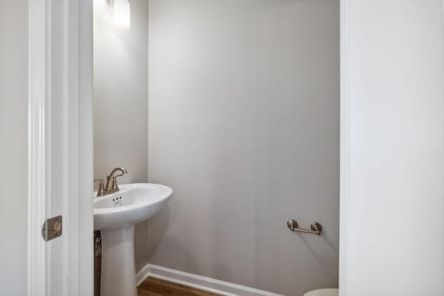 half bath with a sink and baseboards