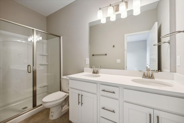 bathroom featuring a stall shower, a sink, and toilet