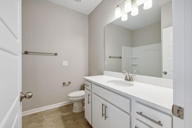 bathroom with baseboards, vanity, and toilet