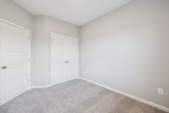 unfurnished bedroom featuring a closet, carpet flooring, and baseboards