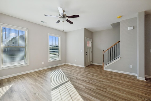 foyer entrance featuring stairs, light wood-type flooring, visible vents, and baseboards