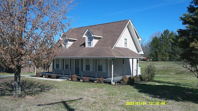 view of front of home with covered porch, roof with shingles, and a front lawn