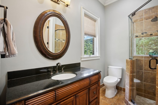 bathroom with toilet, a stall shower, vanity, and baseboards