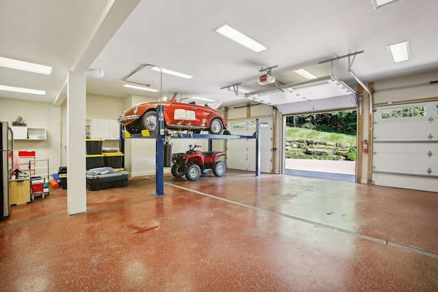 garage featuring freestanding refrigerator and a garage door opener