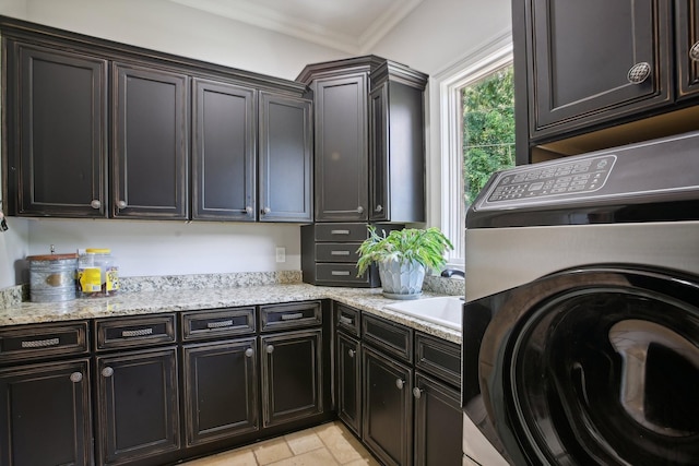 laundry room featuring cabinet space, a sink, washer / dryer, and crown molding