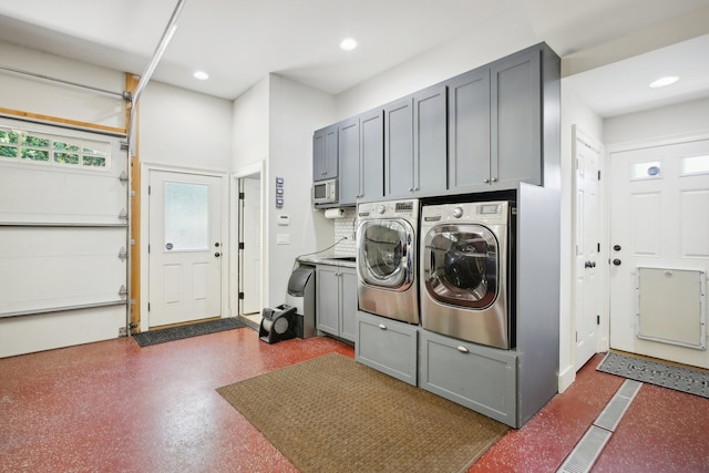 laundry room featuring a garage, cabinet space, washer and clothes dryer, and recessed lighting